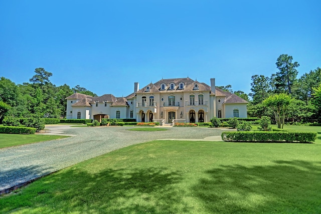 view of front of home with driveway, stucco siding, and a front yard