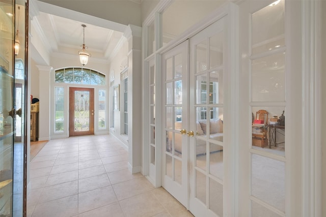 entrance foyer with light tile patterned flooring, french doors, a high ceiling, and ornamental molding