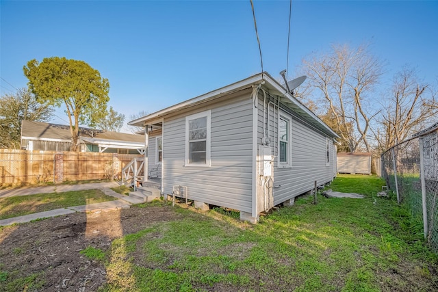 back of house featuring fence private yard, a yard, and entry steps