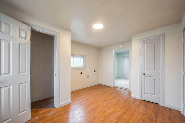 laundry room featuring light wood-type flooring and baseboards