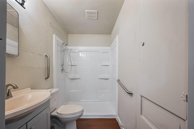 bathroom featuring visible vents, a shower stall, a textured ceiling, and vanity