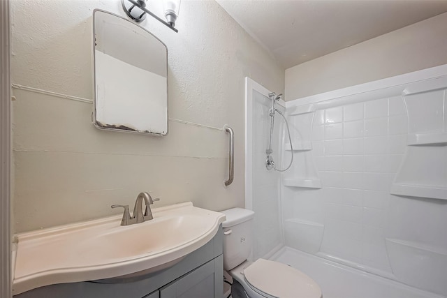 bathroom with vanity, toilet, and walk in shower