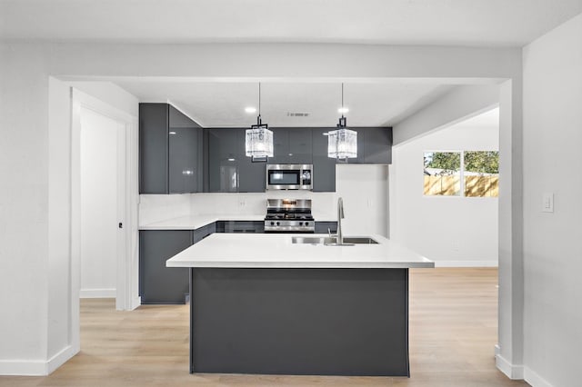 kitchen with modern cabinets, appliances with stainless steel finishes, gray cabinetry, light wood-style floors, and a sink