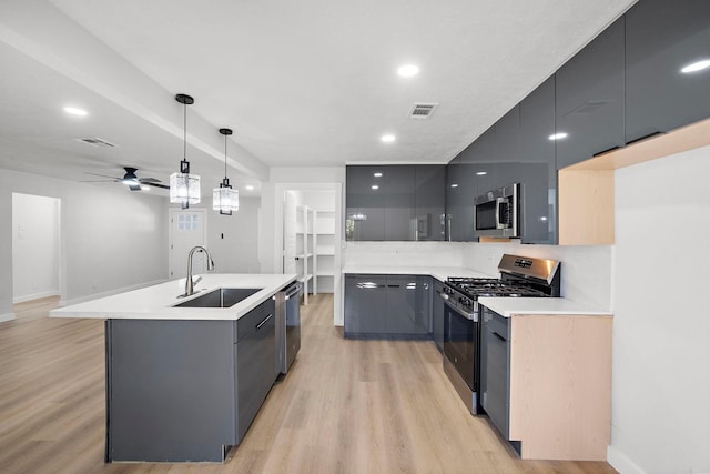 kitchen featuring stainless steel appliances, visible vents, a sink, modern cabinets, and light wood-type flooring