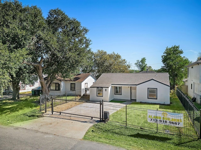 view of front of property with a fenced front yard, stucco siding, a gate, driveway, and a front lawn