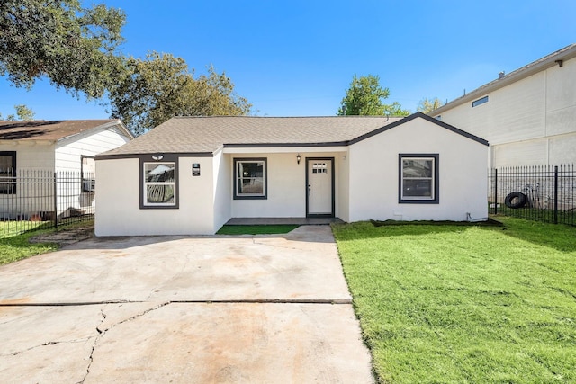 single story home with stucco siding, roof with shingles, fence, and a front yard