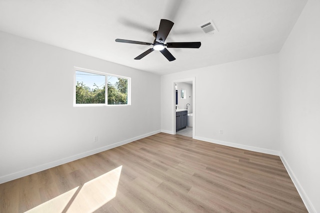 unfurnished bedroom with ceiling fan, visible vents, baseboards, light wood-style floors, and ensuite bath