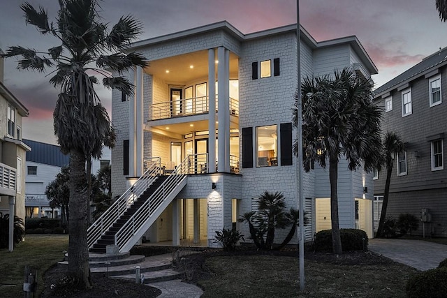 view of front of property featuring a balcony and stairs