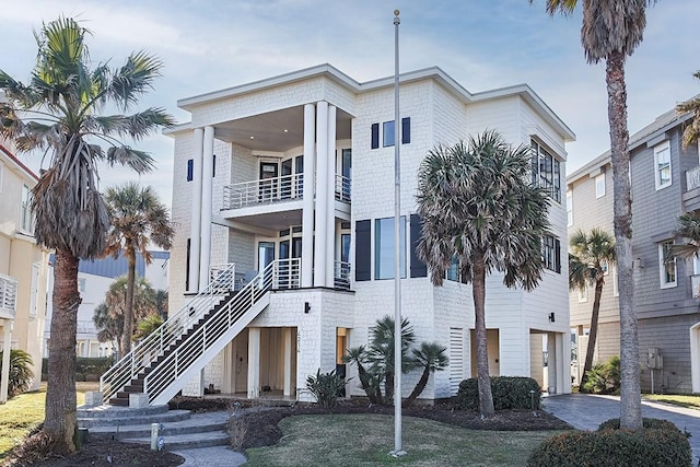 view of property featuring a garage, driveway, and stairs