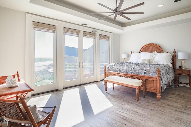4214 Turks Pt, Galveston, TX 77554 - bedroom with access to exterior, a tray ceiling, french doors, visible vents, and wood finished floors