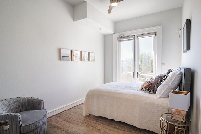 4214 Turks Pt, Galveston, TX 77554 - bedroom featuring ceiling fan, a baseboard radiator, wood finished floors, baseboards, and french doors