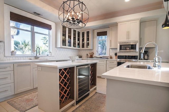 4214 Turks Pt, Galveston, TX 77554 - kitchen featuring visible vents, wine cooler, appliances with stainless steel finishes, a center island, and a sink