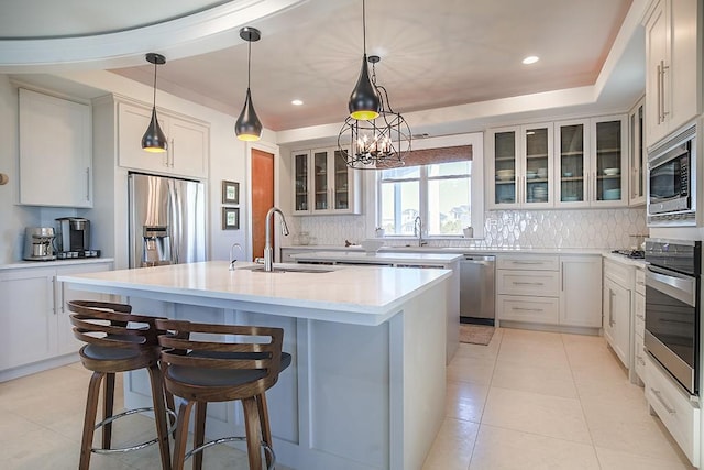 4214 Turks Pt, Galveston, TX 77554 - kitchen with appliances with stainless steel finishes, a kitchen island with sink, a sink, and decorative backsplash