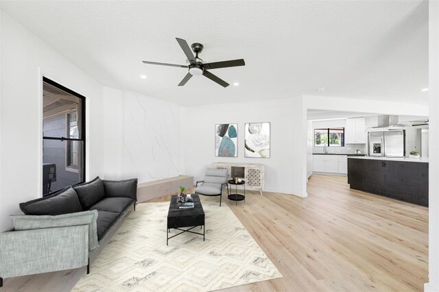 living room featuring a ceiling fan, light wood-type flooring, and recessed lighting