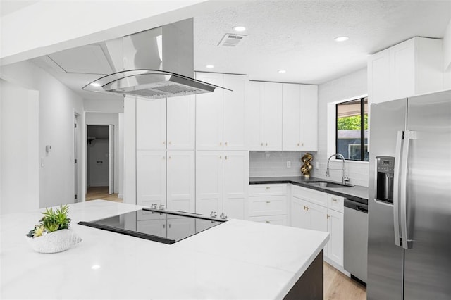 kitchen with visible vents, appliances with stainless steel finishes, a sink, island exhaust hood, and backsplash