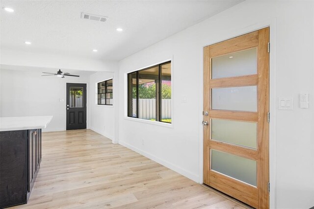 interior space with light wood-style floors, recessed lighting, visible vents, and baseboards