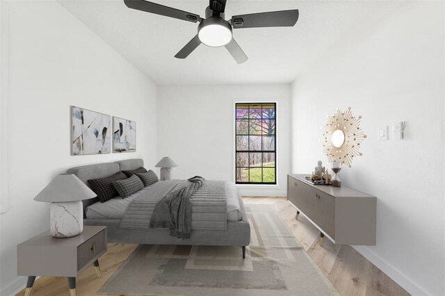 bedroom featuring light wood-style floors, ceiling fan, and baseboards