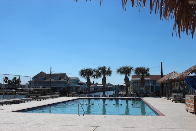 community pool with a patio area and fence