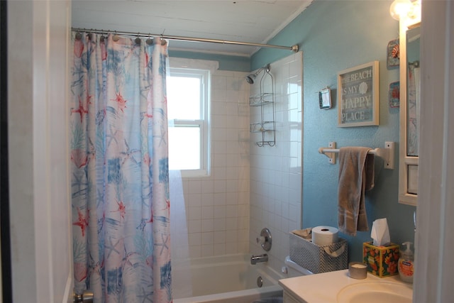 bathroom featuring a textured wall, shower / tub combo with curtain, and vanity