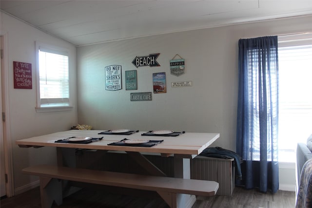 dining space featuring lofted ceiling and wood finished floors