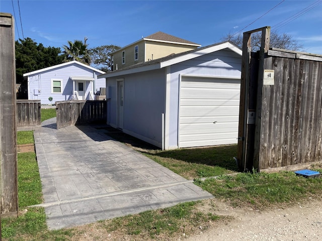 exterior space with a garage, a shingled roof, and fence