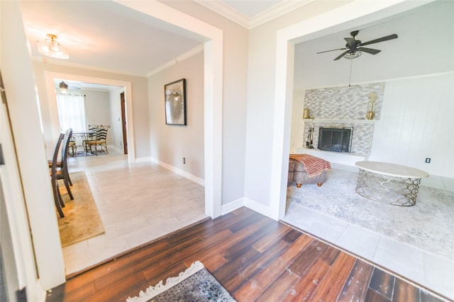 hall featuring baseboards, wood finished floors, and crown molding