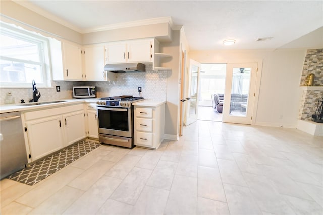 kitchen featuring stainless steel appliances, light countertops, backsplash, a sink, and under cabinet range hood