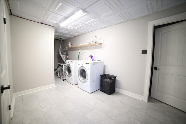 laundry area featuring laundry area, an ornate ceiling, baseboards, and separate washer and dryer