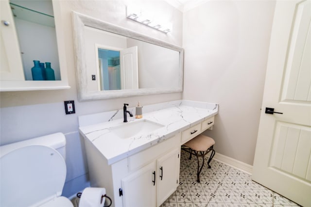 bathroom featuring toilet, tile patterned floors, baseboards, and vanity