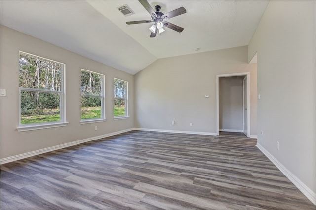 unfurnished room featuring baseboards, visible vents, vaulted ceiling, and wood finished floors