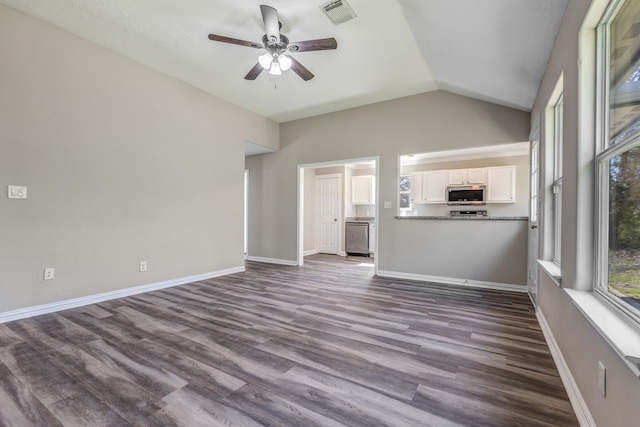 unfurnished living room with baseboards, visible vents, dark wood finished floors, a ceiling fan, and vaulted ceiling