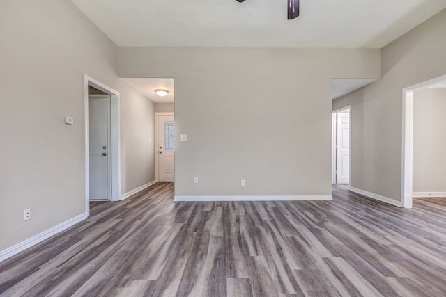 empty room with a ceiling fan, baseboards, and wood finished floors