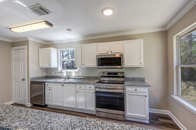 kitchen featuring visible vents, dark wood-style floors, appliances with stainless steel finishes, white cabinetry, and a sink