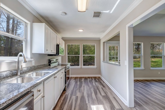 kitchen with visible vents, ornamental molding, stainless steel appliances, white cabinetry, and a sink