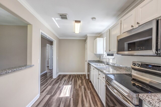 kitchen featuring a sink, white cabinets, appliances with stainless steel finishes, dark wood finished floors, and crown molding