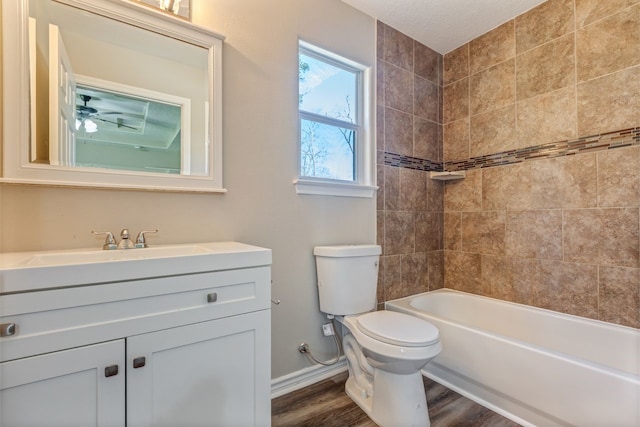 bathroom featuring toilet, wood finished floors, vanity, bathing tub / shower combination, and baseboards