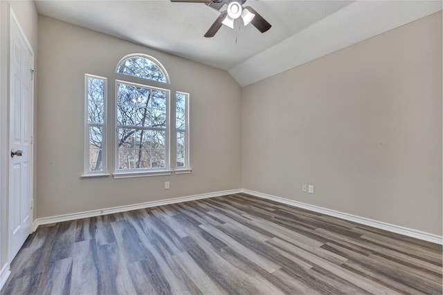 spare room featuring vaulted ceiling, ceiling fan, baseboards, and wood finished floors