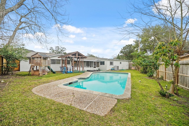 view of swimming pool with a fenced in pool, a playground, a sunroom, a fenced backyard, and a yard