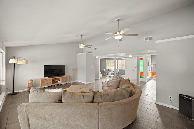 living area featuring visible vents, a ceiling fan, baseboards, and vaulted ceiling