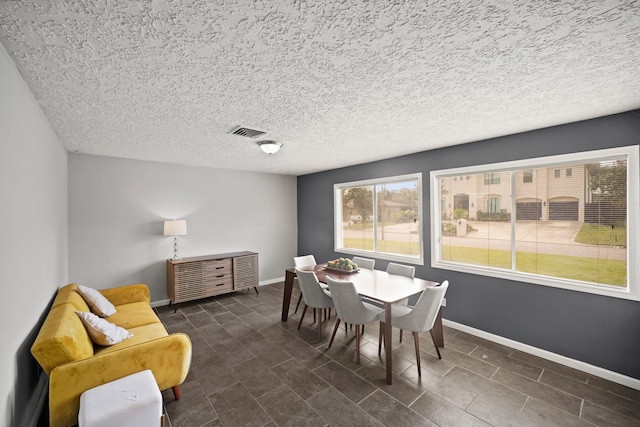 dining space featuring visible vents, baseboards, and a textured ceiling