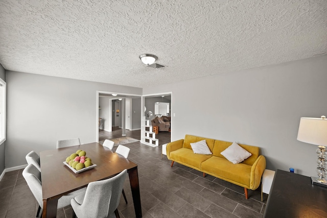 dining area with baseboards, visible vents, and a textured ceiling