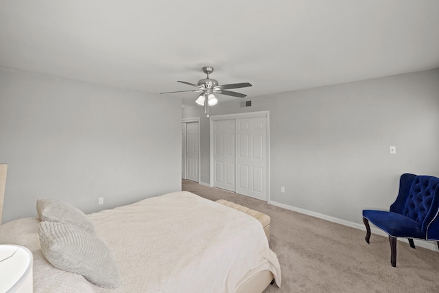 carpeted bedroom with baseboards, visible vents, two closets, and ceiling fan