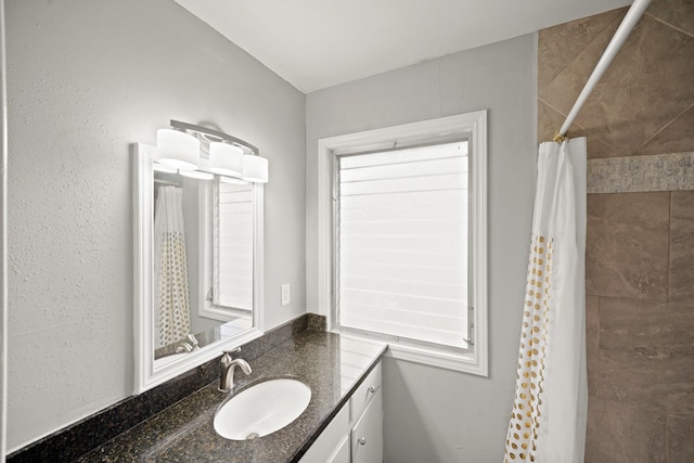 full bath featuring vanity and tiled shower