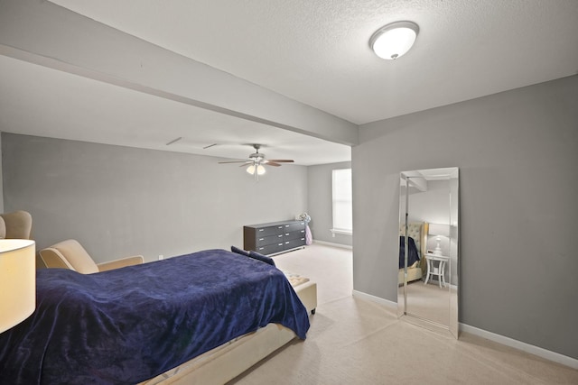 bedroom with a textured ceiling, baseboards, and light carpet