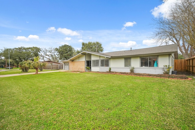 view of front of property with stucco siding, a front lawn, driveway, fence, and a garage