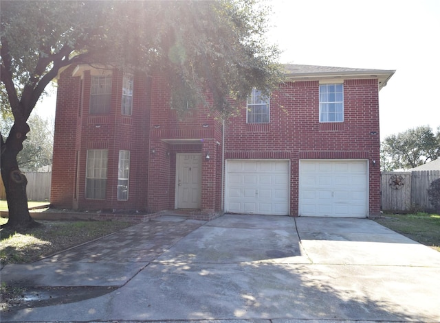 view of front of home featuring driveway, brick siding, an attached garage, and fence