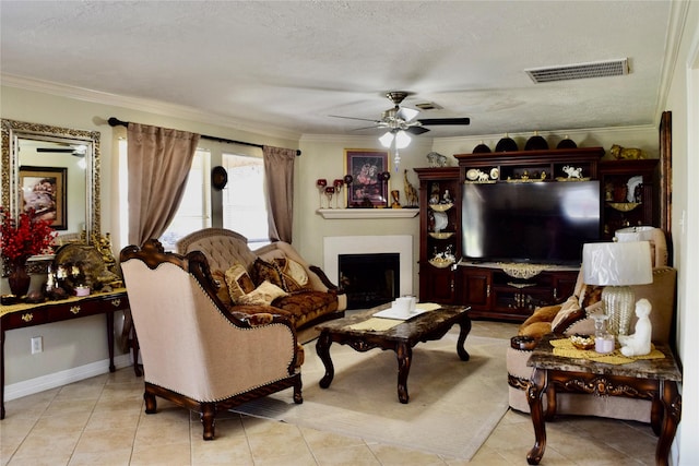 living room featuring a ceiling fan, visible vents, crown molding, and a fireplace