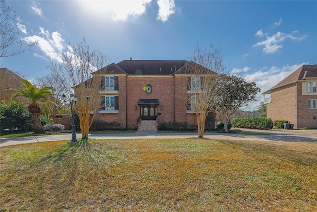 view of front of house with brick siding and a front yard