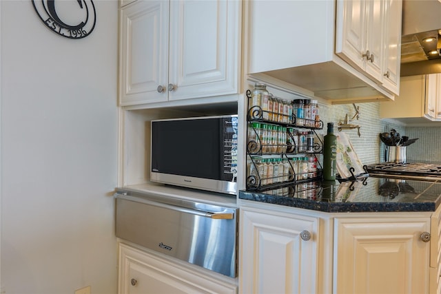 kitchen with white cabinetry, backsplash, and extractor fan