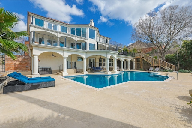 rear view of house featuring a patio, stucco siding, a ceiling fan, a balcony, and stairs